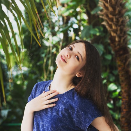 Young pretty woman posing near beautiful flowers