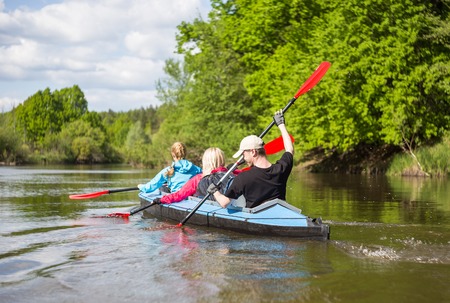 Young people are kayaking on a river in beautiful nature. Summer sunny day in outdoor.の写真素材
