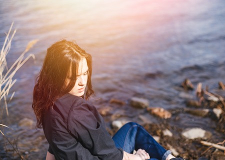 Young pretty teenage woman posing in city park near river .の写真素材