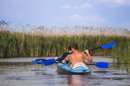 Young people are kayaking on a river in beautiful nature.の写真素材