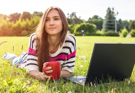 oung fashionable woman relax after work with laptop in city park.