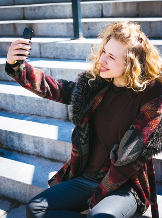 Young Hipster curly woman relax in the city downtown.の写真素材