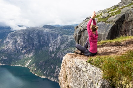 Young woman feel freedom on Kerag. Happy woman enjoy beautiful lake and good weather in Norwayの写真素材
