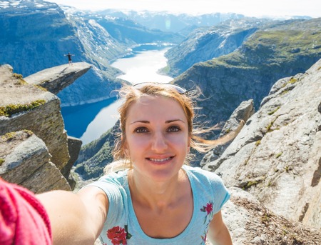 Happy girl enjoy beautiful lake and good weather in Norway.の写真素材