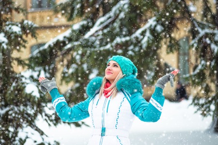 Young happy woman enjoy snow in winter city park outdoor.の写真素材