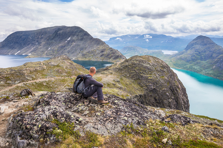Young man hiking on Besseggen. Happy man enjoy lake and good weather in Norwayの写真素材