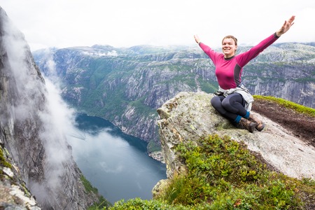 Happy people relax in cliff during trip Norway. hiking route