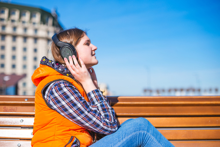 Happy teenage girl listenind to music and time in the cityの写真素材