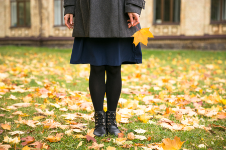 Happy woman walking in autumn city park. Rainy weather and yellow trees aroundの写真素材