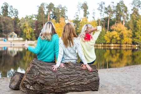 Happy girls having fun spend time together in autumn city parkの写真素材