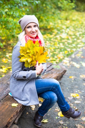 Pretty woman on backdrop of autumn leaves - seasonal relax conceptの写真素材