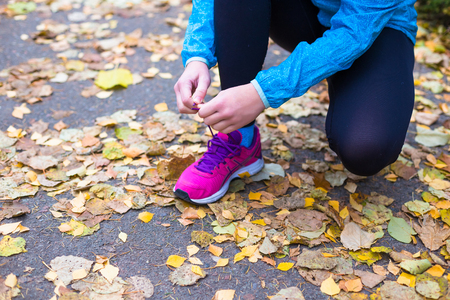 Young sport woman doing exercises during autumn training outsideの写真素材