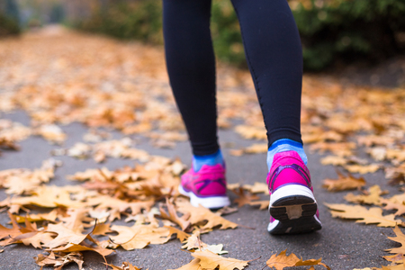 Young sport woman doing exercises during autumn training outsideの写真素材
