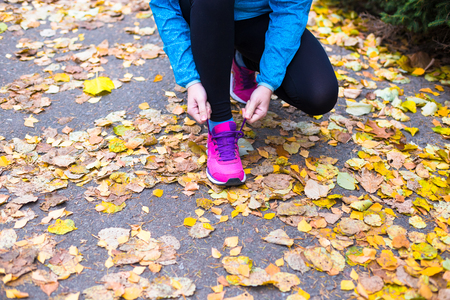 Young sport woman doing exercises during autumn training outsideの写真素材