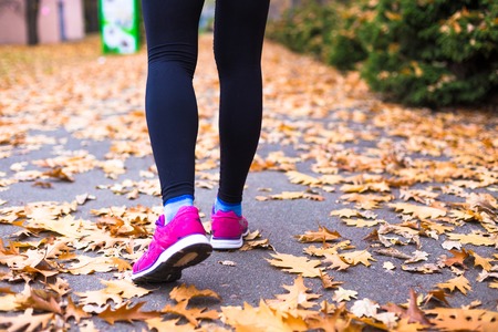 Young sport woman doing exercises during autumn training outsideの写真素材