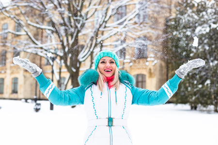 Young happy woman enjoy snow in winter city park outdoor.の写真素材