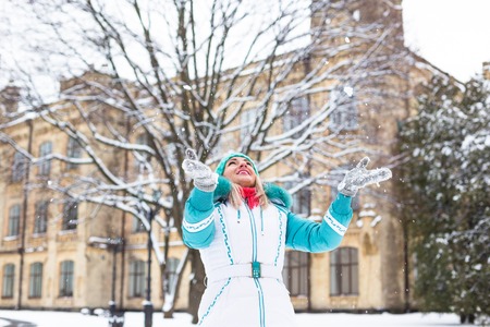 Young happy woman enjoy snow in winter city park outdoor.の写真素材