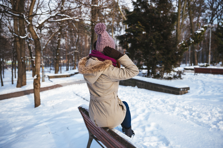 Happy redhead woman walking in winter park and enjoy the snowの写真素材