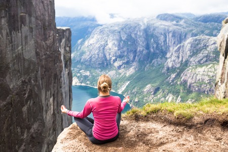 Young woman hiking on kjerag. Happy girl enjoy beautiful lake and good weather in Norwayの写真素材