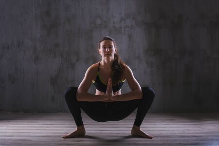 Fitness woman training in dark studio. Young girl posing on black backgroundの写真素材