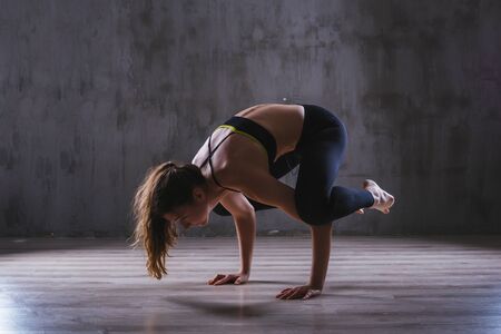 Fitness woman training in dark studio. Young girl posing on black backgroundの写真素材
