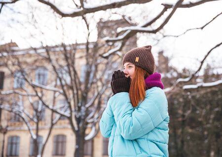 Happy redhead woman walking in winter park and enjoy the snowの写真素材