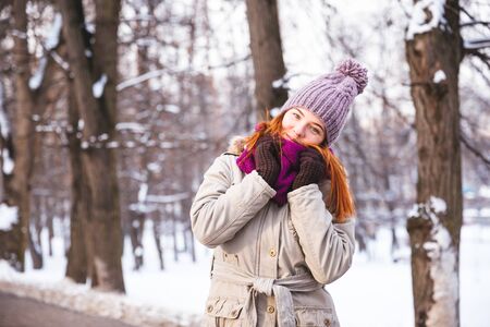 Happy redhead woman walking in winter park and enjoy the snowの写真素材