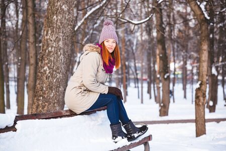 Happy redhead woman walking in winter park and enjoy the snowの写真素材