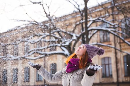 Happy redhead woman walking in winter park and enjoy the snowの写真素材