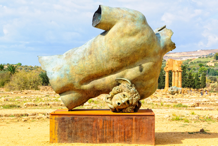 Back and head of Igor Mitoraj`s bronze sculpture, Torso di Ikaro, and the Temple of Castor and Pollux - Agrigento, Sicily, Italy, 19 October 2011のeditorial素材
