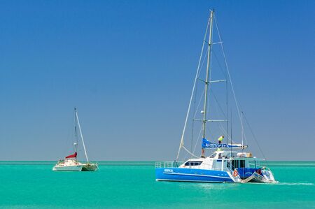 Two graceful catamarans on green water under blue sky - Monkey Mia, WA, Australiaのeditorial素材