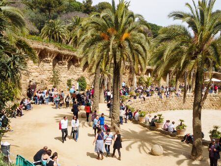 Tourists and locals enjoy the spring sunshine at the Greek Theatre in Park Guell - Barcelona, Catalonia, Spainのeditorial素材