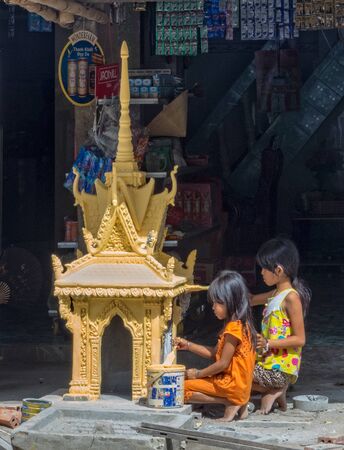 Children paint a yellow pagoda in preparation for the Vietnamese New Year - Tra Vinh, Vietnamのeditorial素材