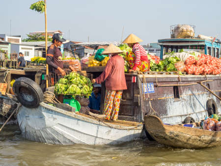 Locals are trading goods from their boats in the floating market on the Mekong River Delta - Cai Rang, Vietnamのeditorial素材
