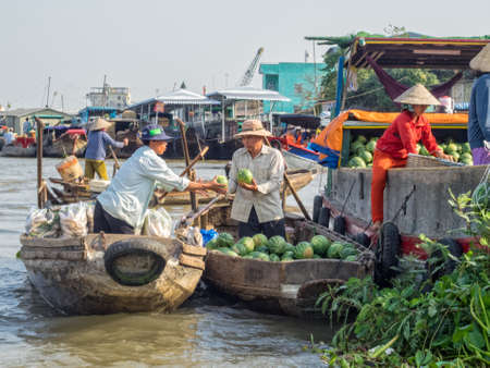 Locals are trading goods from their boats in the floating market on the Mekong River Delta - Cai Rang, Vietnamのeditorial素材