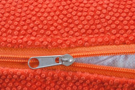 studio shot of orange zipper, halfway open.の写真素材