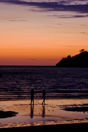 sunset near a mountain in nosy be madagascar and two people in the beachの写真素材