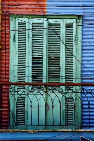 green wood venetian blind and a red blue metal wall in la boca buenos aires argentinaの写真素材