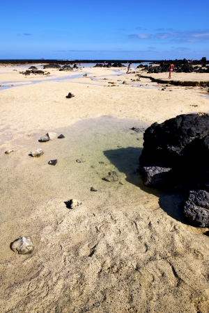 people footstep coaststone  volcanic spain  water in lanzarote  sky cloud beach  and summer 