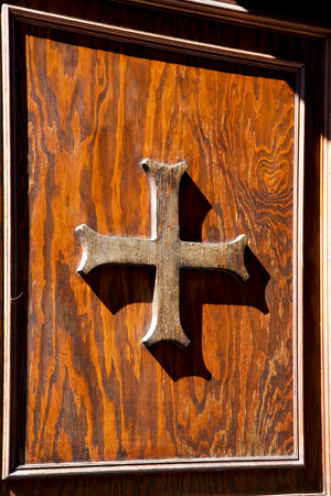 abstract cross   brass brown knocker in a   closed wood door  castiglione olona varese italyの写真素材