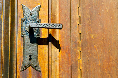 castellanza blur lombardy   abstract   rusty brass brown knocker in a  door curch  closed wood italy   crossの写真素材