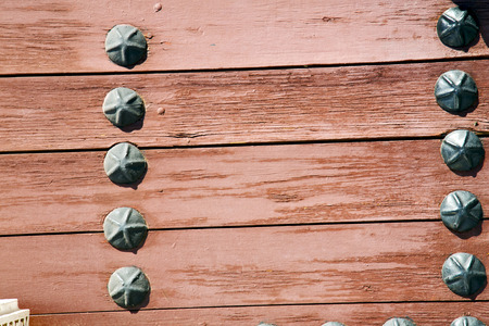 Stripped paint in the blue  wood door and rusty   nail