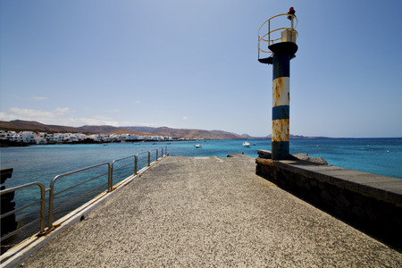 lighthouse and pier boat in the blue sky   arrecife teguise lanzarote spainの写真素材