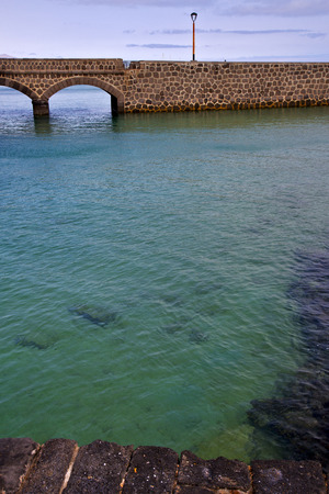atlantic ocean lanzarote  bridge and street lamp in the blue sky   arrecife teguise spainの写真素材