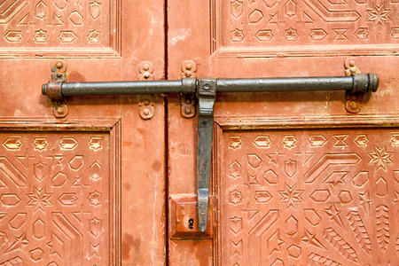 morocco knocker in africa the old wood  facade home and rusty safe padlockの写真素材