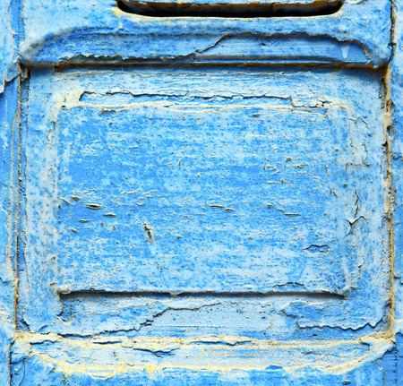 stripped paint in the blue wood door and rusty nailの写真素材