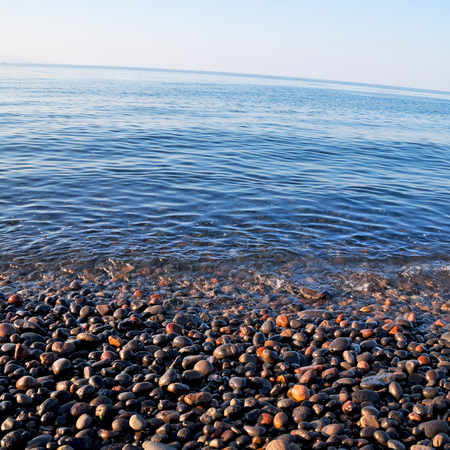 stone in the coastline sunrise and light ocean     white skyの写真素材