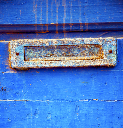 stripped paint in the blue wood door and rusty  nailの写真素材