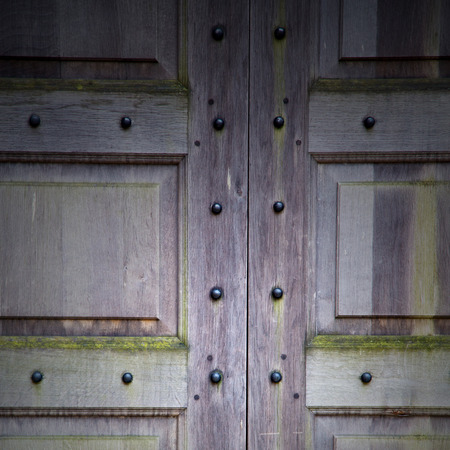in london antique brown door  rusty  brass nail and lightの写真素材