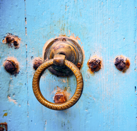 metal nail dirty stripped paint in the brown   red wood door and rusty  knockerの写真素材